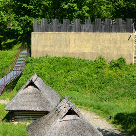 zrekonstruowane chaty słowiańskie i wczesnośredniowieczny wał przekładkowy